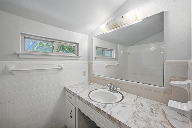 2913 Portales Dr, Fort Worth, TX 76116 - bathroom featuring vaulted ceiling, vanity, tile walls, and wainscoting