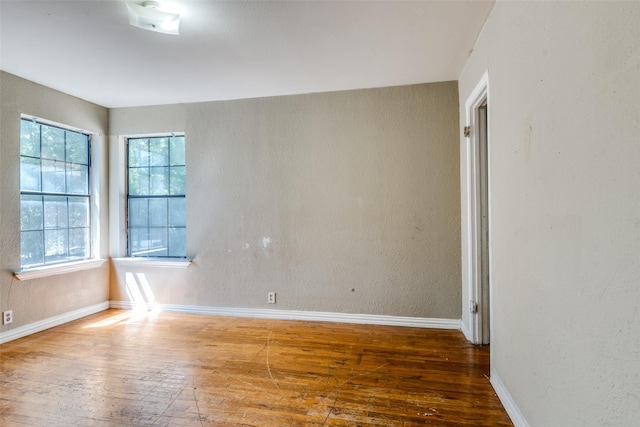 711 W State St, Terrell, TX 75160 - spare room with wood-type flooring, baseboards, and a textured wall