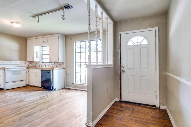 711 W State St, Terrell, TX 75160 - doorway to outside with light wood-style floors, track lighting, baseboards, and a sink