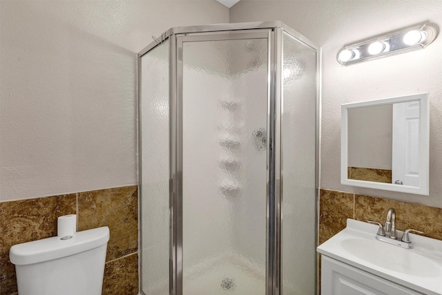 616 Bellevue Dr, Cleburne, TX 76033 - bathroom featuring tile walls, a shower stall, toilet, and vanity