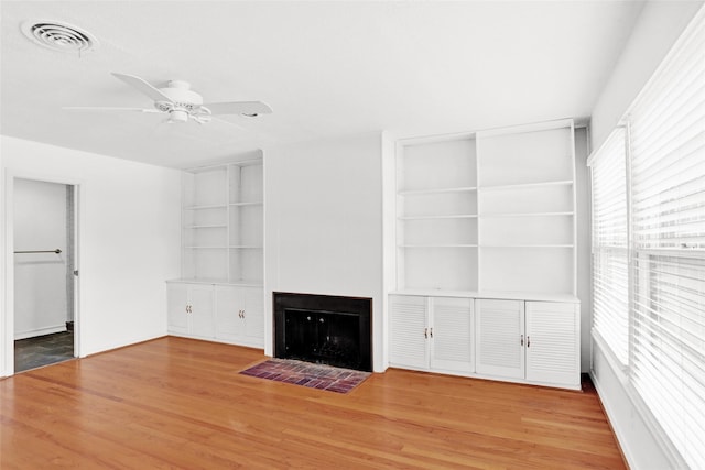 10533 Solta Dr, Dallas, TX 75218 - unfurnished living room with built in shelves, ceiling fan, a fireplace with flush hearth, and wood finished floors