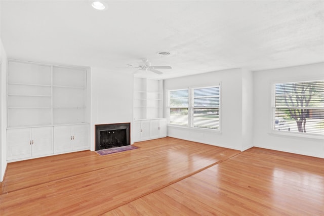 10533 Solta Dr, Dallas, TX 75218 - unfurnished living room featuring healthy amount of natural light, built in shelves, a ceiling fan, and light wood finished floors