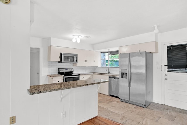 10533 Solta Dr, Dallas, TX 75218 - kitchen featuring appliances with stainless steel finishes, a sink, a peninsula, backsplash, and stone countertops