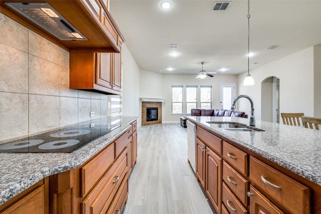 3608 Walden Dr, Mckinney, TX 75071 - kitchen featuring black electric stovetop, custom range hood, a sink, brown cabinetry, and a ceiling fan