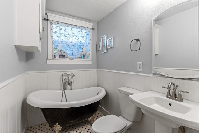 715 S Barnett Ave, Dallas, TX 75211 - bathroom with a wainscoted wall, a freestanding tub, toilet, and a sink