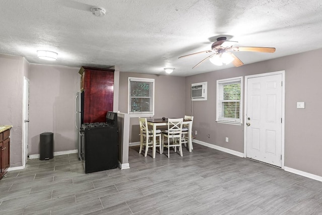 715 S Barnett Ave, Dallas, TX 75211 - dining room featuring ceiling fan, a textured ceiling, baseboards, an AC wall unit, and light wood-type flooring
