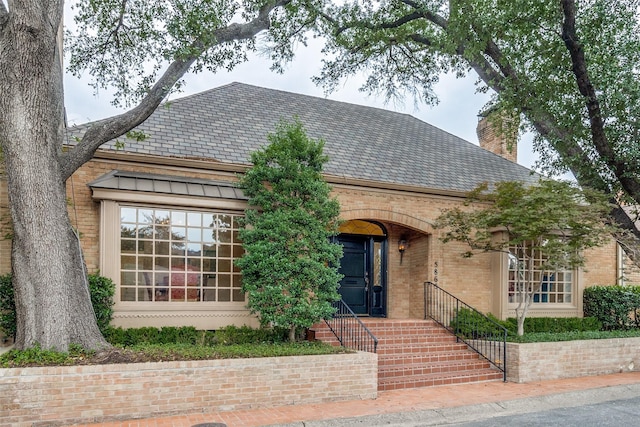 5865 Farquhar Ln, Dallas, TX 75209 - view of front facade with a high end roof, brick siding, and a chimney