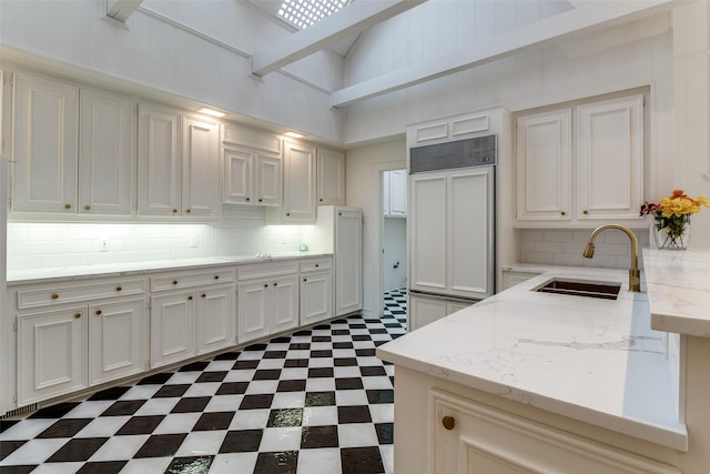 5865 Farquhar Ln, Dallas, TX 75209 - kitchen featuring a sink, dark floors, backsplash, light stone counters, and a peninsula