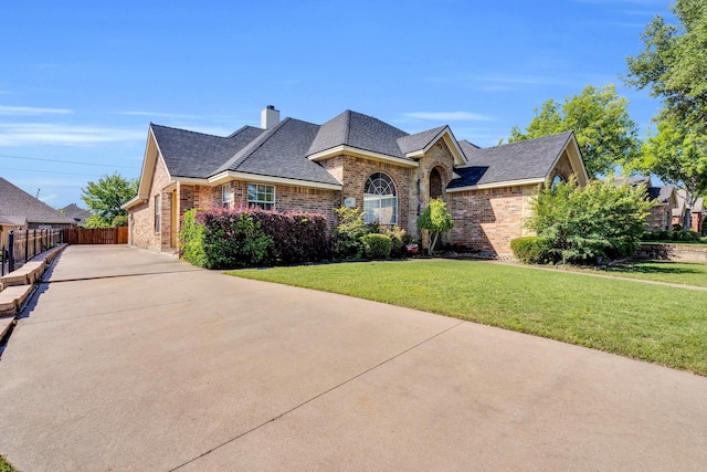 1607 W Westhill Dr, Cleburne, TX 76033 - french country home featuring brick siding, roof with shingles, concrete driveway, and a chimney