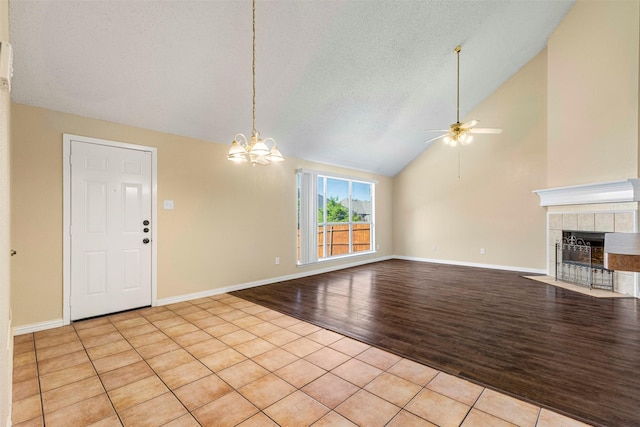 4953 Sunset Ridge Dr, Fort Worth, TX 76123 - unfurnished living room with a ceiling fan, a fireplace, light wood finished floors, a chandelier, and baseboards