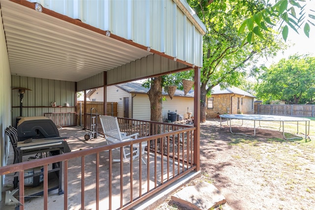 426 Brown Ave, Tuscola, TX 79562 - view of patio / terrace with a trampoline, a wooden deck, an outbuilding, and central AC unit