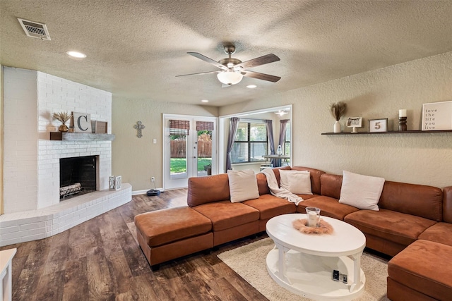3701 Nocona Dr, Granbury, TX 76049 - living area with a textured ceiling, ceiling fan, wood finished floors, a textured wall, and a fireplace