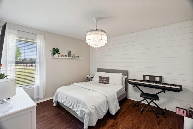 3701 Nocona Dr, Granbury, TX 76049 - bedroom with dark wood-style flooring, baseboards, wood walls, and a chandelier