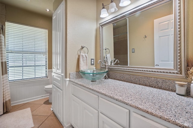 3701 Nocona Dr, Granbury, TX 76049 - full bathroom with toilet, vanity, tile patterned floors, and a wainscoted wall
