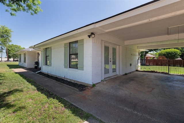 3701 Nocona Dr, Granbury, TX 76049 - view of side of property featuring french doors, brick siding, and an attached carport