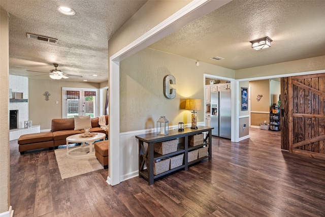 3701 Nocona Dr, Granbury, TX 76049 - living area featuring a textured ceiling, dark wood-style floors, ceiling fan, and a fireplace