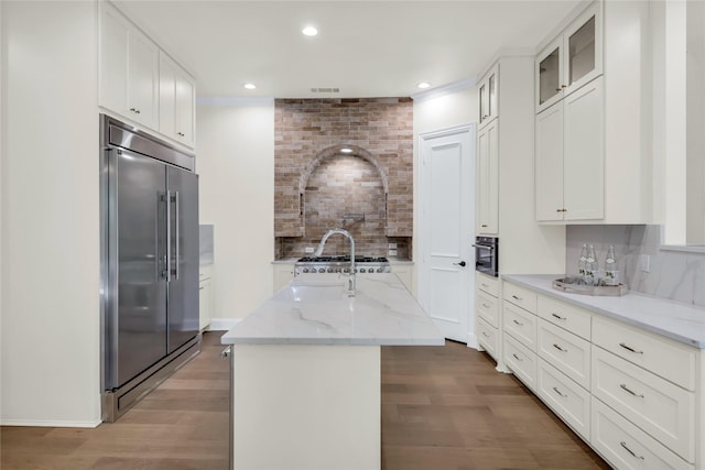 6628 Castle Pines Dr, Plano, TX 75093 - kitchen featuring stainless steel appliances, backsplash, wood finished floors, light stone counters, and recessed lighting