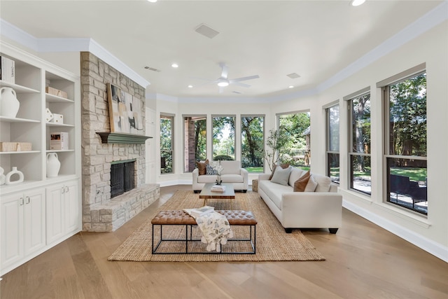 6628 Castle Pines Dr, Plano, TX 75093 - living area featuring healthy amount of natural light, ornamental molding, ceiling fan, wood finished floors, and a fireplace