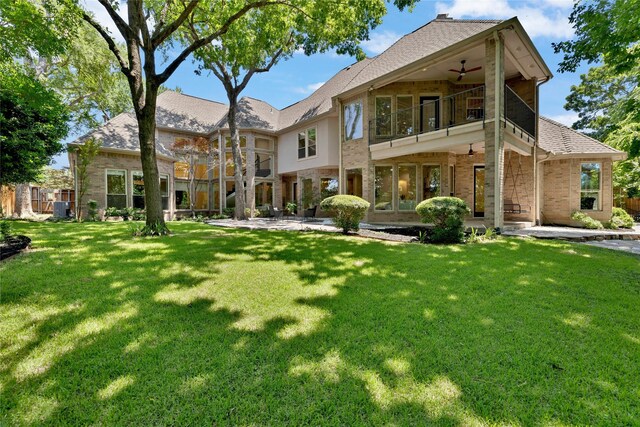 6628 Castle Pines Dr, Plano, TX 75093 - rear view of house featuring ceiling fan, a balcony, a patio, a lawn, and brick siding