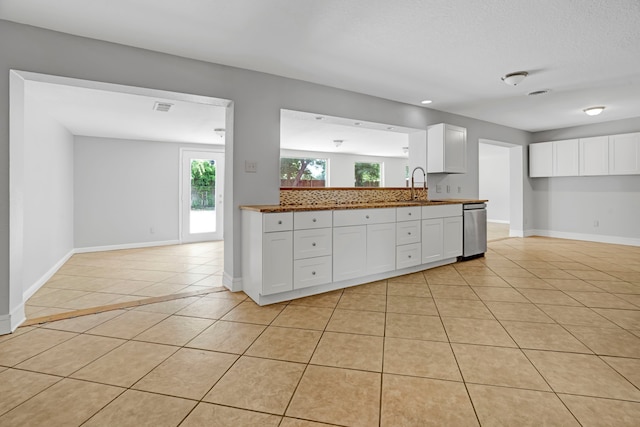 229 Cotillion Rd, Fort Worth, TX 76134 - kitchen with stainless steel dishwasher, light tile patterned flooring, baseboards, and white cabinetry
