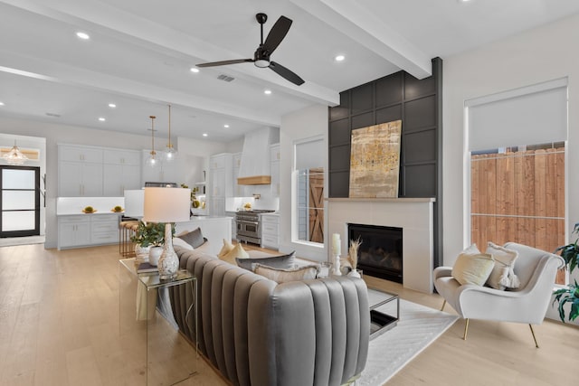 317 Rusk St, Roanoke, TX 76262 - living room with beamed ceiling, light wood-style flooring, a ceiling fan, a fireplace, and recessed lighting