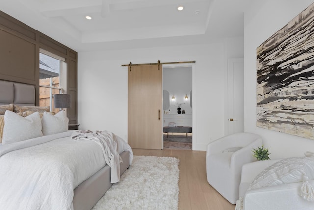 317 Rusk St, Roanoke, TX 76262 - bedroom featuring a barn door, light wood-type flooring, recessed lighting, ensuite bath, and a tray ceiling