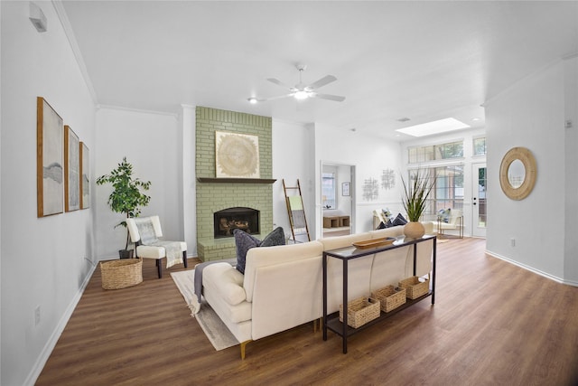 4321 Boca Raton Dr, The Colony, TX 75056 - living room featuring wood finished floors, a ceiling fan, a brick fireplace, baseboards, and ornamental molding