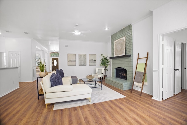 4321 Boca Raton Dr, The Colony, TX 75056 - living area featuring wood finished floors, a brick fireplace, ceiling fan, baseboards, and crown molding