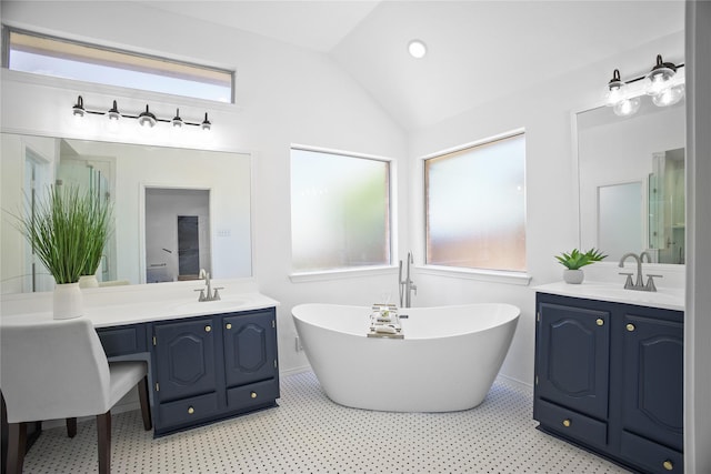 4321 Boca Raton Dr, The Colony, TX 75056 - full bathroom featuring a freestanding bath, two vanities, vaulted ceiling, plenty of natural light, and tile patterned floors