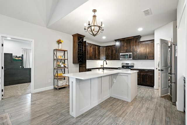 120 Oak Hill Rd, Tuscola, TX 79562 - kitchen with stainless steel appliances, light wood-style floors, dark brown cabinetry, light countertops, and a chandelier