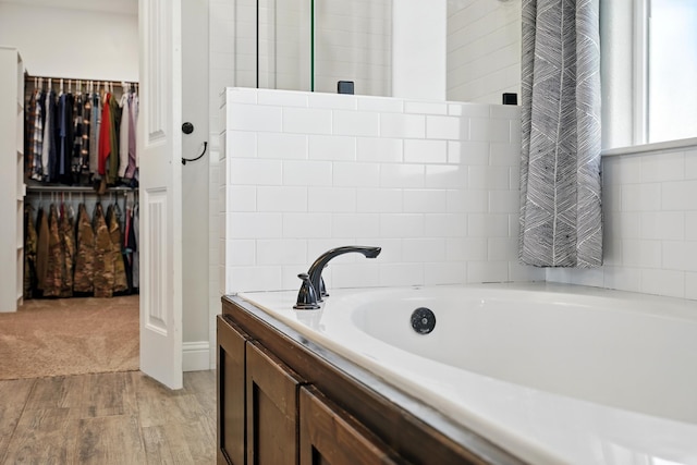 120 Oak Hill Rd, Tuscola, TX 79562 - bathroom with a garden tub, a spacious closet, and wood finished floors