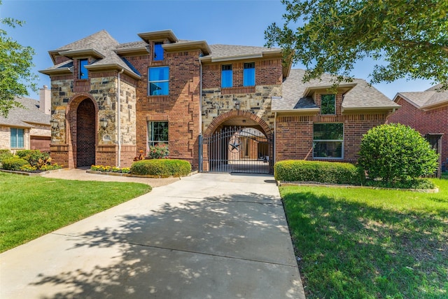 2028 Sterling Trace Dr, Keller, TX 76248 - view of front of home with a gate, concrete driveway, a front lawn, brick siding, and stone siding