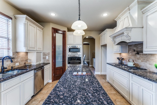 2028 Sterling Trace Dr, Keller, TX 76248 - kitchen with appliances with stainless steel finishes, arched walkways, a sink, backsplash, and custom range hood