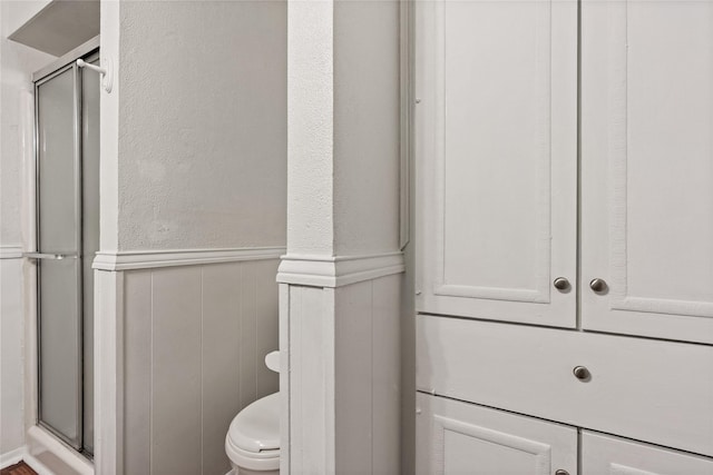 2111 Chippendale Dr, Mckinney, TX 75071 - bathroom with a wainscoted wall, a shower stall, and toilet