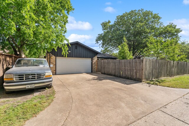 2111 Chippendale Dr, Mckinney, TX 75071 - view of property exterior with board and batten siding, brick siding, concrete driveway, and a garage