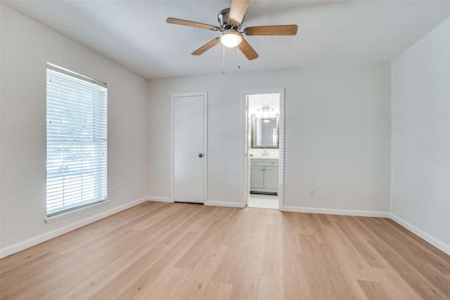 5210 Stagecoach Ln, Garland, TX 75043 - unfurnished bedroom featuring light wood-type flooring, baseboards, a sink, ensuite bathroom, and ceiling fan