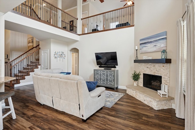 10308 Hidden Haven Dr, Mckinney, TX 75072 - living room featuring ceiling fan, a towering ceiling, stairway, dark wood-style flooring, and arched walkways