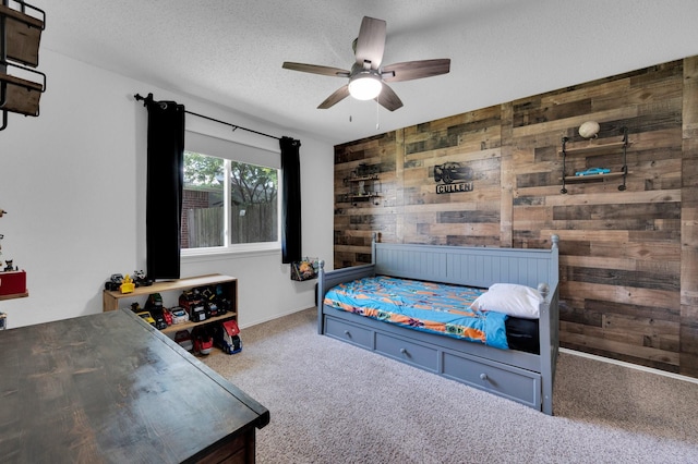 3214 Eagle Ln, Midlothian, TX 76065 - bedroom with wood walls, carpet, ceiling fan, and a textured ceiling