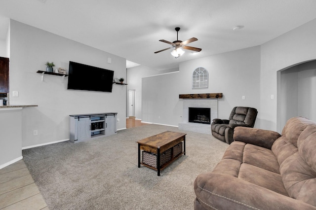 3214 Eagle Ln, Midlothian, TX 76065 - tiled living room featuring ceiling fan, arched walkways, a brick fireplace, baseboards, and carpet floors