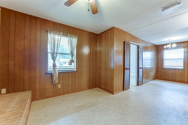 307 E Rio Grande St, Garland, TX 75041 - empty room featuring plenty of natural light, tile patterned floors, a chandelier, and wooden walls