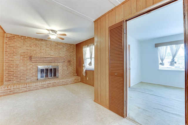 307 E Rio Grande St, Garland, TX 75041 - unfurnished living room featuring a ceiling fan, a brick fireplace, wooden walls, and baseboards