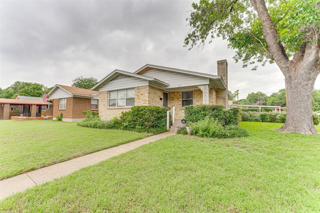 307 E Rio Grande St, Garland, TX 75041 - ranch-style home with a chimney, brick siding, a front yard, and a porch
