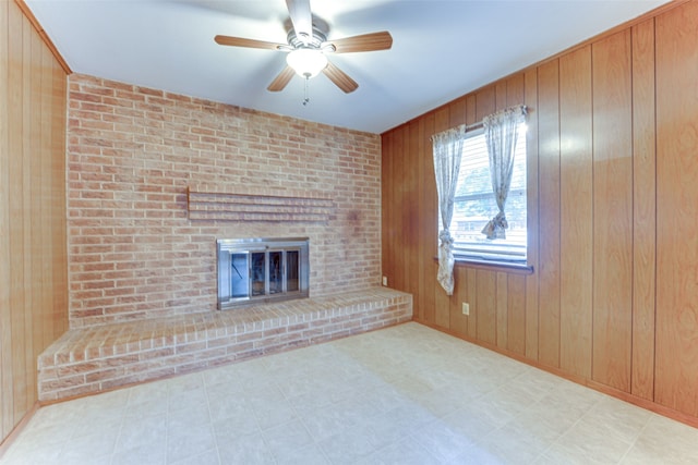 307 E Rio Grande St, Garland, TX 75041 - unfurnished living room with a brick fireplace, a ceiling fan, wood walls, and tile patterned floors