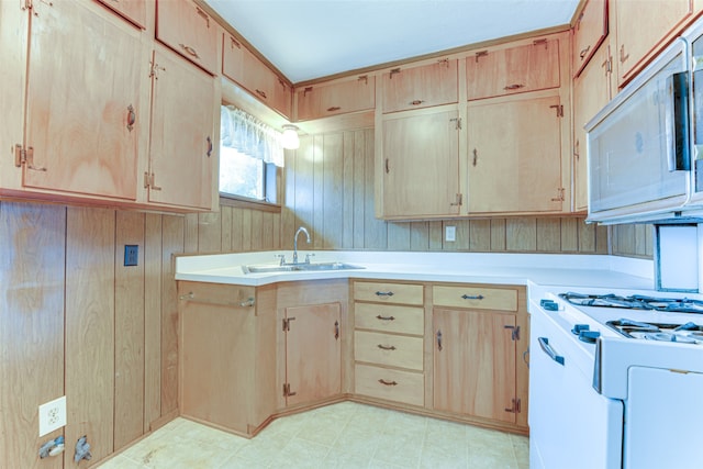 307 E Rio Grande St, Garland, TX 75041 - kitchen with a sink, white appliances, light brown cabinets, light countertops, and wood walls