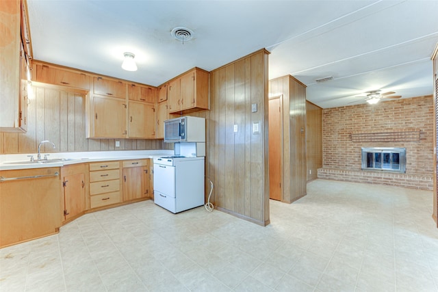 307 E Rio Grande St, Garland, TX 75041 - kitchen featuring white gas range oven, stainless steel microwave, wood walls, light countertops, and a ceiling fan