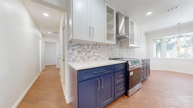 2350 Ravenwood Dr, Grand Prairie, TX 75050 - kitchen with electric range, wall chimney range hood, white cabinets, light countertops, and tasteful backsplash