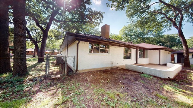 2350 Ravenwood Dr, Grand Prairie, TX 75050 - back of house with a chimney, a gate, brick siding, and a patio