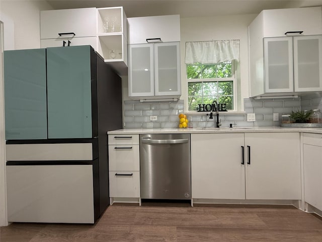 201 E 10th St, Kaufman, TX 75142 - kitchen with stainless steel dishwasher, white cabinets, backsplash, and freestanding refrigerator