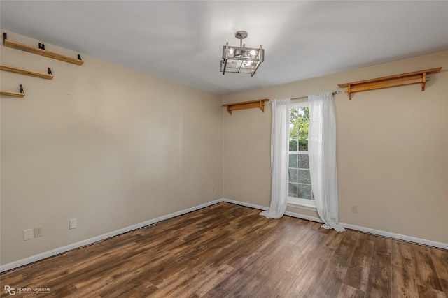 3820 Fairfield Ave Unit 113, Shreveport, LA 71104 - unfurnished room with wood finished floors, baseboards, and a chandelier