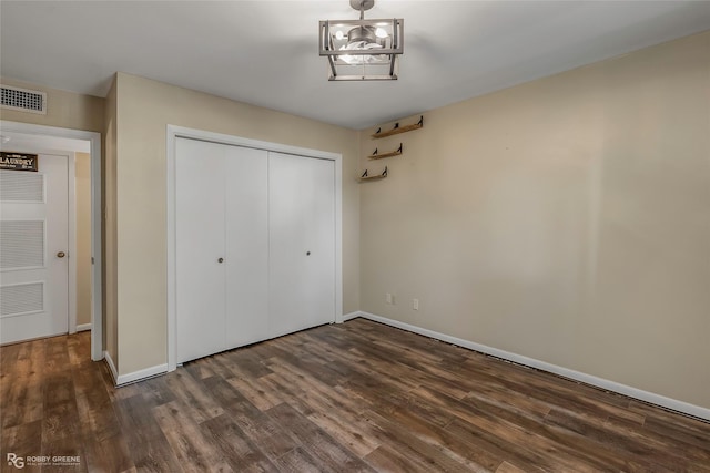 3820 Fairfield Ave Unit 113, Shreveport, LA 71104 - unfurnished bedroom featuring dark wood-style floors, baseboards, and a closet